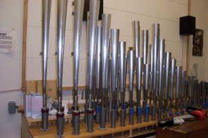 Row of metal organ pipes on tuning rack
